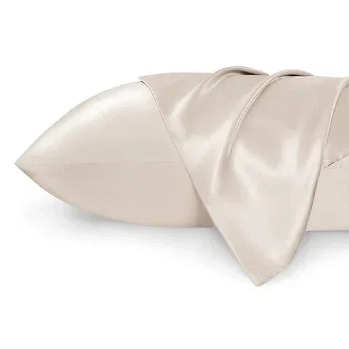 Beige silk pillowcase, soft, on an ergonomic pillow for deep sleep and comfort.